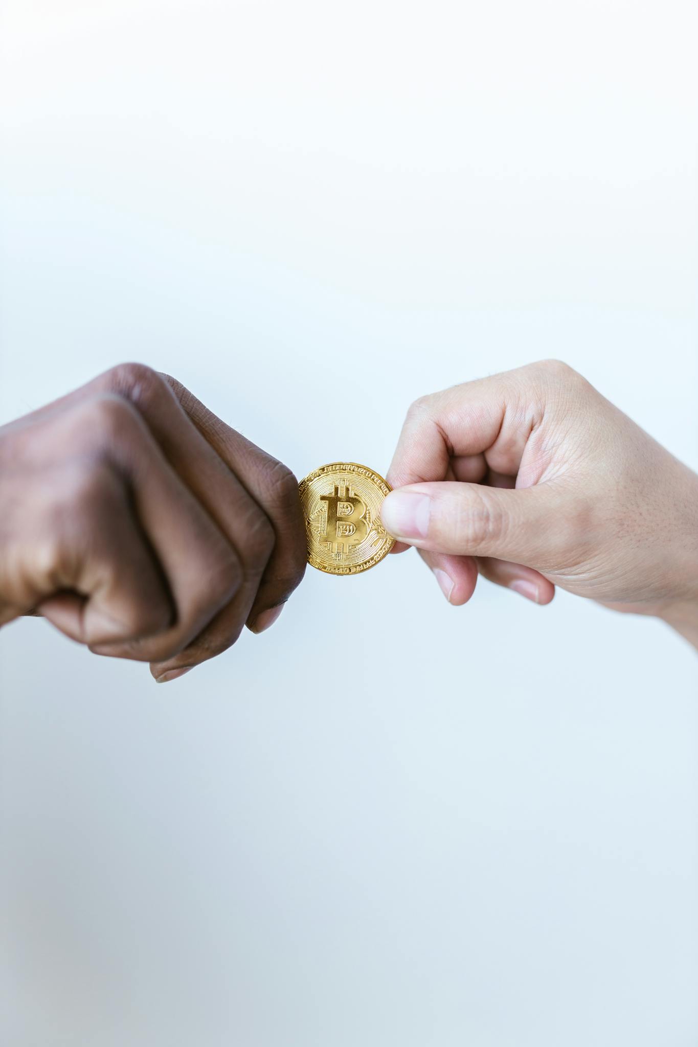 Close-Up Shot of Two People Holding a Gold Coin